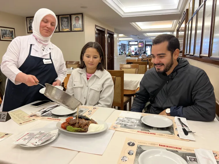 Guests at the table as a dish is brought out on the Istanbul Evening Food Tour