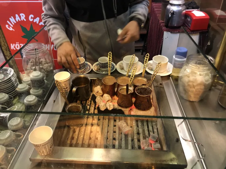 A vendor preparing a taste at his counter