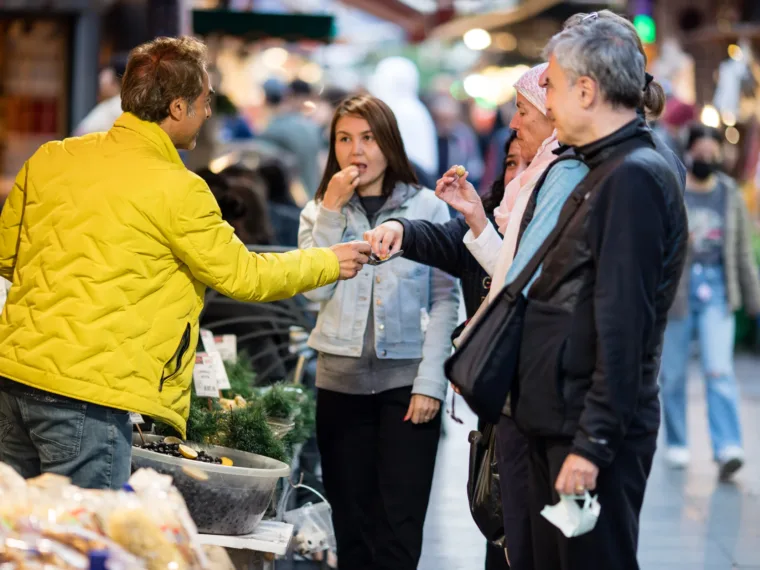 The guide handing round a taste in a busy Istanbul market street