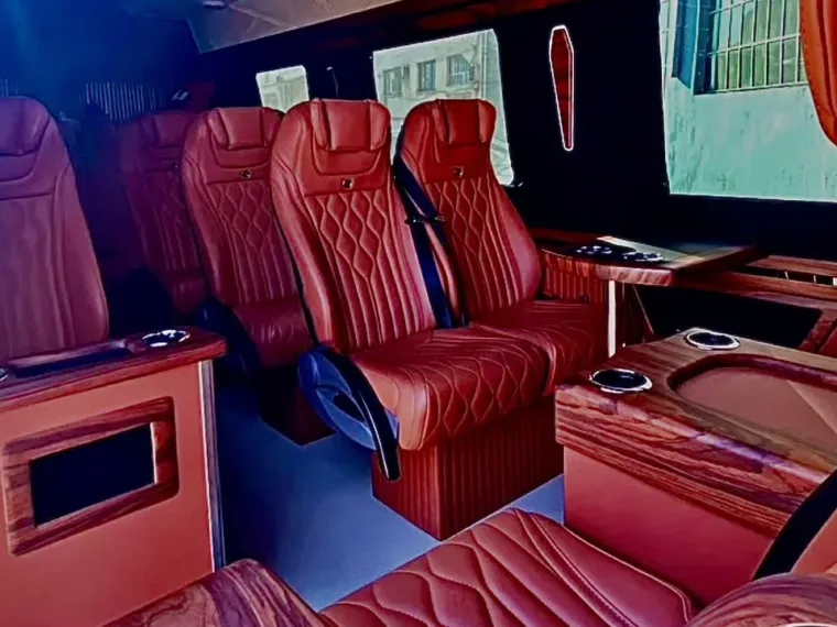 Inside the Mercedes Sprinter, with reclining leather seats and tables between them