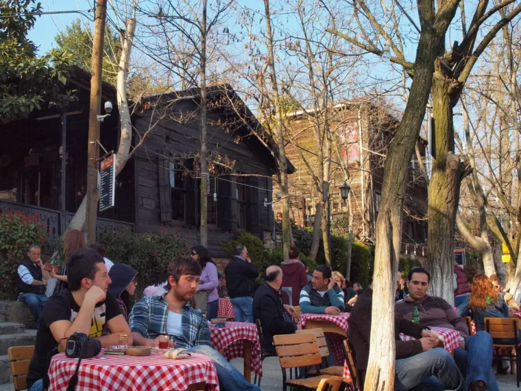 Guests around checked tablecloths at an outdoor tea garden in Istanbul
