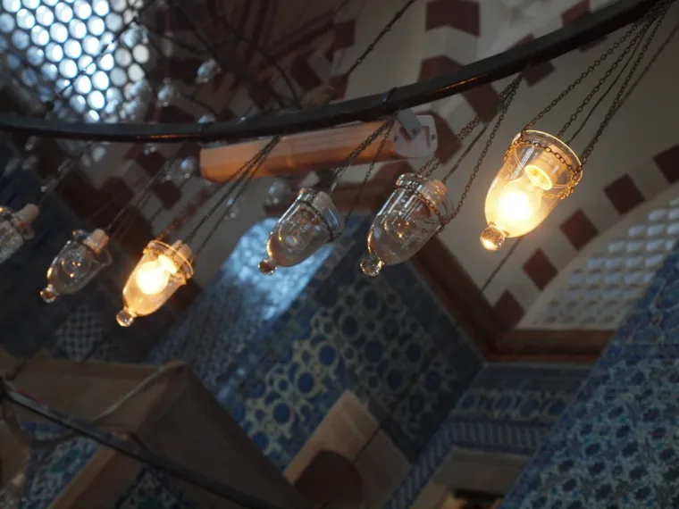 Glass lamps hanging beneath the painted dome of a mosque