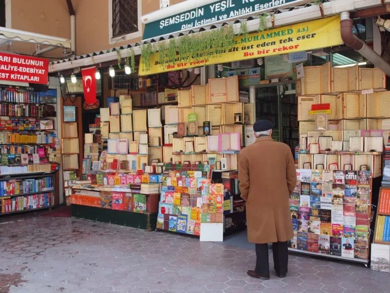 A man browsing books and prints at an Istanbul street bookseller