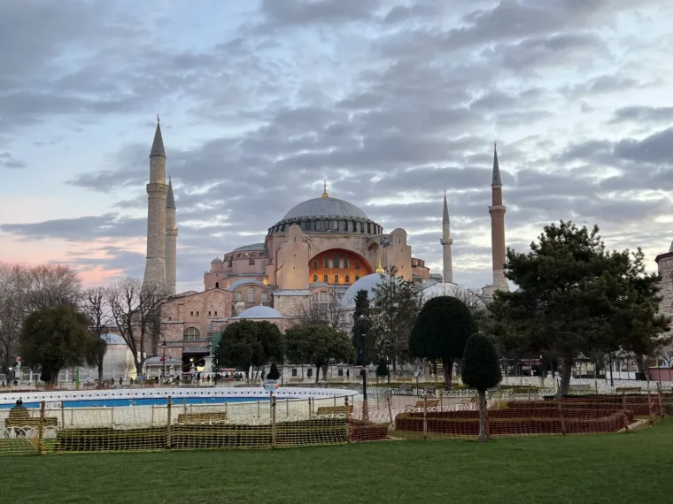 Hagia Sophia at dusk, its dome and four minarets seen across the gardens of Sultanahmet