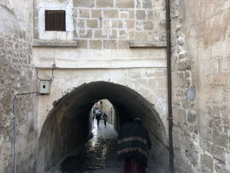 A vaulted stone passage running under the old houses of a town in southeastern Turkey
