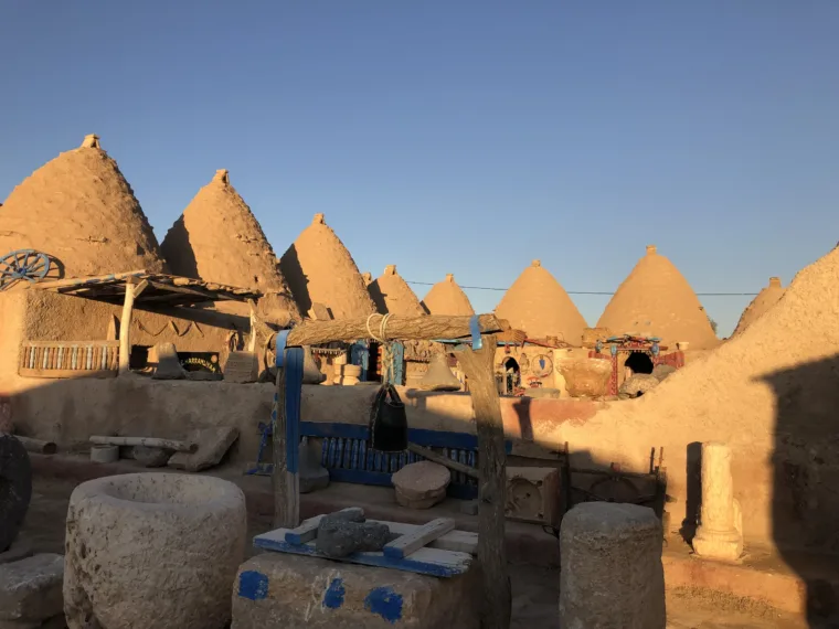 The courtyard of the Harran beehive houses, with millstones and blue painted fittings
