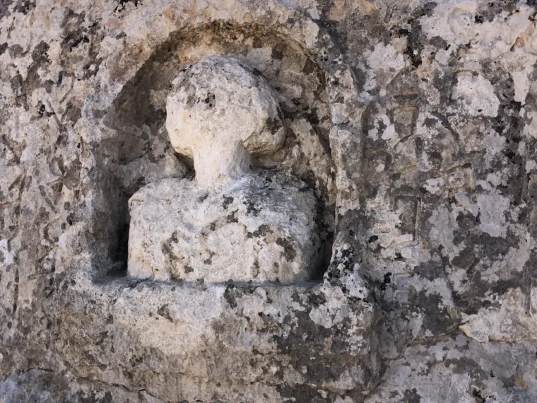 A carved figure set in a rounded niche in the limestone