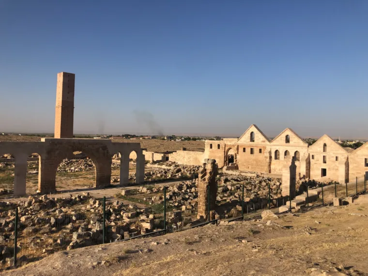 The arches and tower of the Harran ruins with the beehive houses beyond
