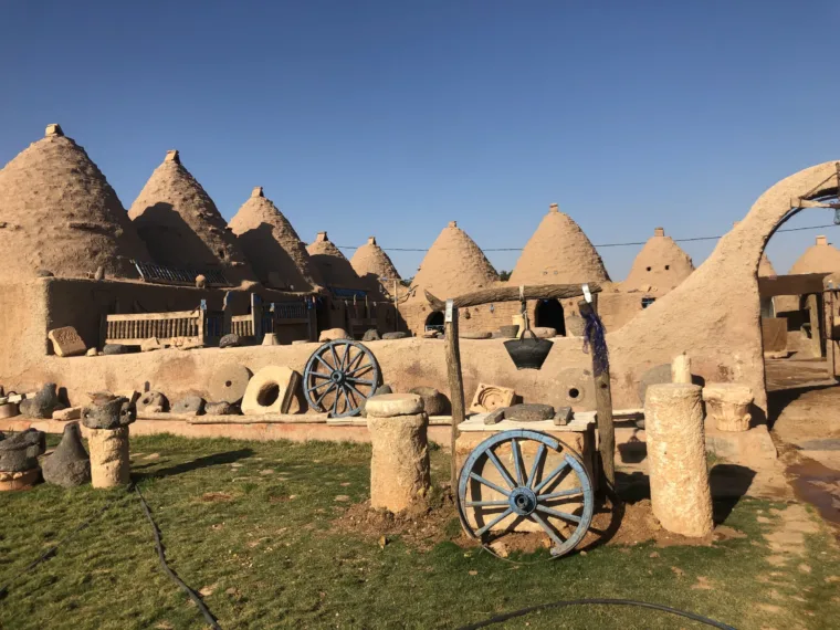 A cart and grinding stones in the garden of the Harran beehive houses