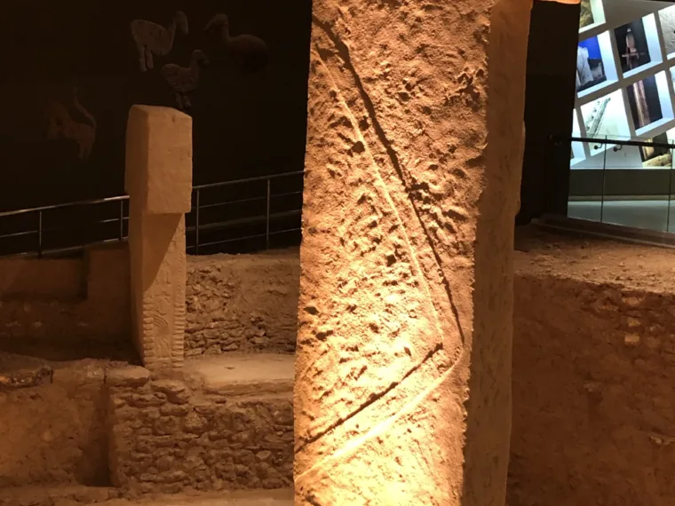 A carved pillar from Göbekli Tepe lit in the Şanlıurfa museum
