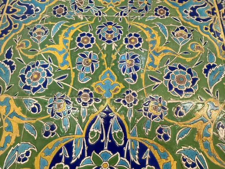 Iznik tiles in blue, green and yellow floral patterns on a mosque wall in Istanbul