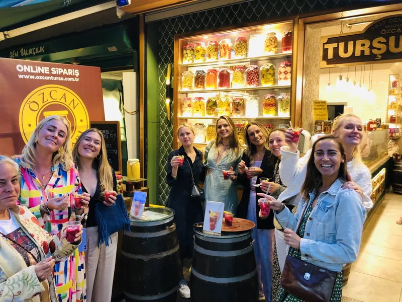 A group of guests laughing together during a food tour stop