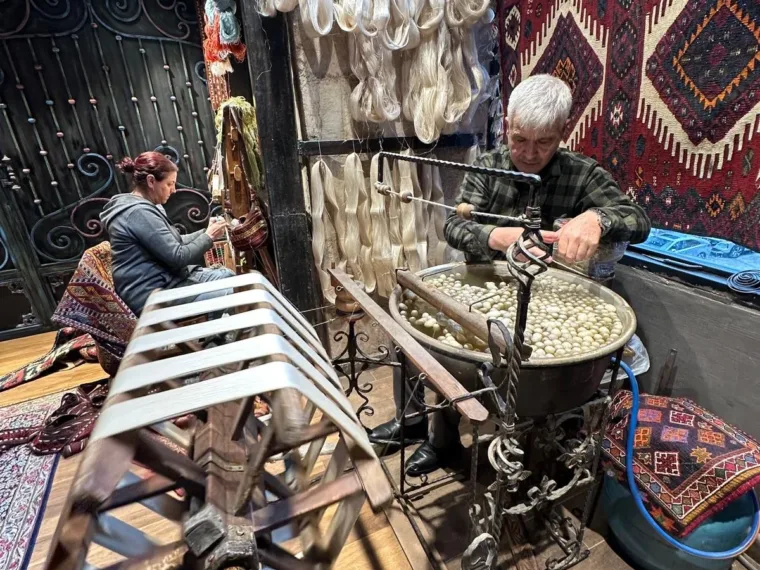 Silk cocoons in a copper basin, the thread reeled off by hand